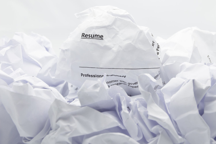 Crumpled up resume on a pile of paper trash